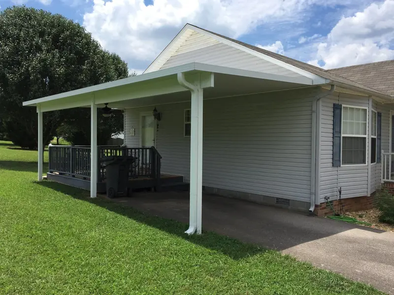 Attached carport and covered porch on a home with vinyl siding