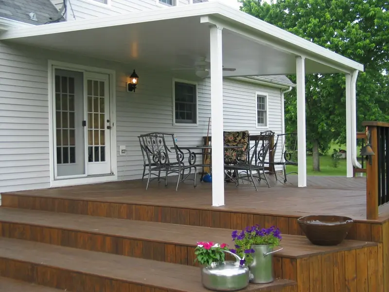 White insulated patio cover over a stained wood deck with a dining set